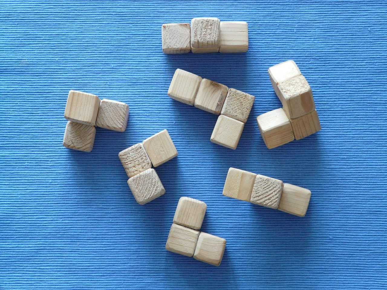 蓝色桌垫上摆着不同形状的木质拼搭积木
